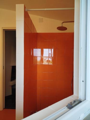 a mirror in a bathroom with a red tiled wall at Villa Haass in Stintino