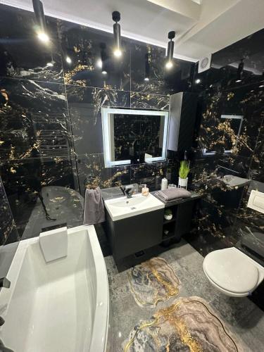 Un baño con bañera, lavabo e inodoro. en Residential 1, en Baia Mare