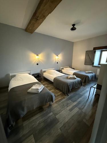 two beds in a room with wooden floors at Gites Le Grand Tornage in Évaux-les-Bains