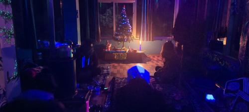 a group of people in a room with a christmas tree at Formosa cafe & hostel in Kasol