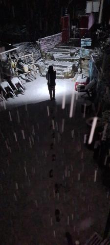 a person walking down a street at night at Formosa cafe & hostel in Kasol