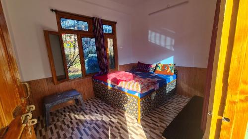 a room with a bed in the corner of a room at Formosa cafe & hostel in Kasol