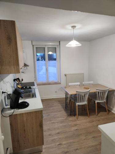 une cuisine et un salon avec une table et des chaises dans l'établissement Appartement meublé 6 personnes à deux pas du centre-ville, à Saint-Dizier