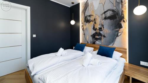 two beds in a bedroom with a painting on the wall at Apartamenty Good Time - Belle View - Centrum in Szklarska Poręba