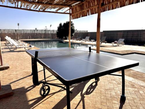 a ping pong table in front of a swimming pool at Villa Sans vis à vis, ensoleillée avec piscine in Douar Ouled Ahmed