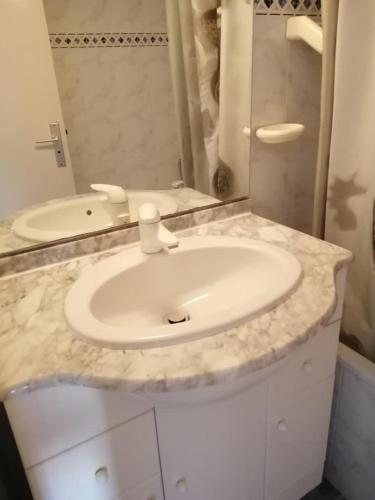 une salle de bain avec un lavabo blanc et un miroir dans l'établissement CAP7 Studio Cap d'Agde Centre port, au Cap d'Agde