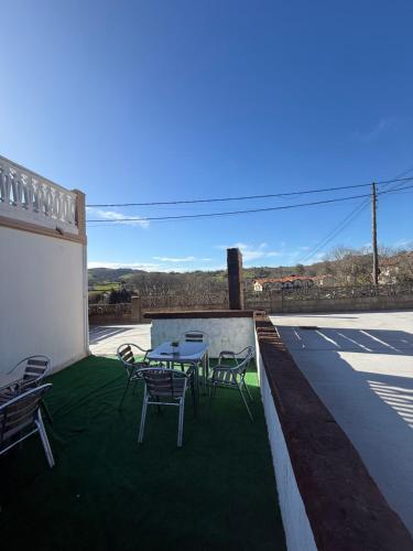 a patio with a table and chairs on the grass at La casuca de Candela in Santillana del Mar