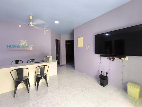Una habitación con un bar y un televisor en la pared. en Hudhu Velaa, en Atolón Baa