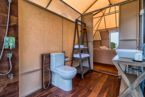 a bathroom with a toilet and a sink in a tent at Kodev in Kalpitiya