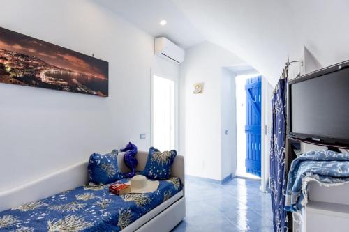 a living room with a couch and a flat screen tv at Blue Angels Relais - De Vivo Realty Meta di Sorrento in Meta