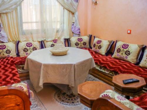 a living room with a table and a couch at Appartement à louer aourir Tamraght in Aourir