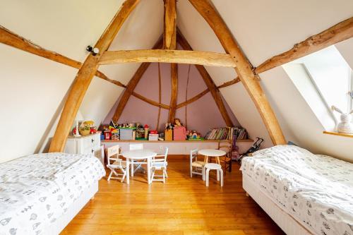 - 2 lits dans une chambre dotée de parquet et de fenêtres dans l'établissement Longère entre mer et campagne, à Hubersent