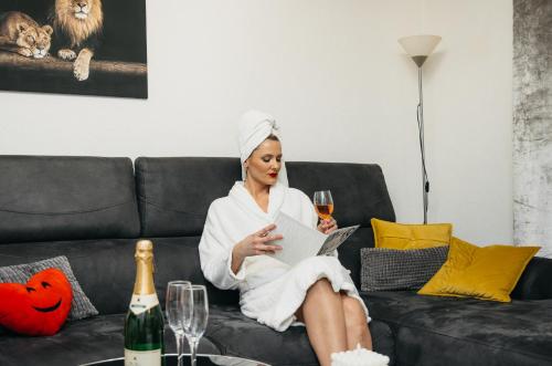 a woman sitting on a couch with a glass of wine at DolceVita in Vinkovci