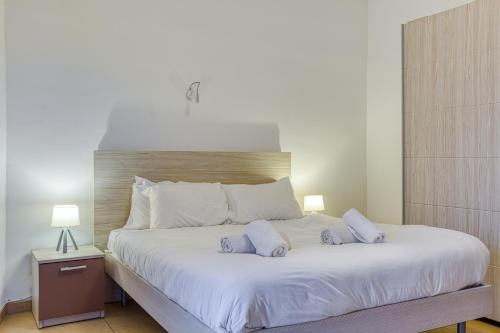 a bedroom with a large bed with two pillows on it at Bright,stylish 2bedroom apartment in village centre in Kalkara
