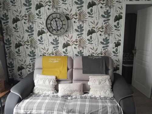 - un canapé dans une chambre avec une horloge sur un mur dans l'établissement Appartement au pied des remparts avec place de parking, à Boulogne-sur-Mer