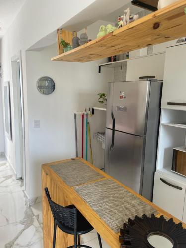 サン・ビセンテにあるSala living 809の木製のテーブルと冷蔵庫のあるキッチン