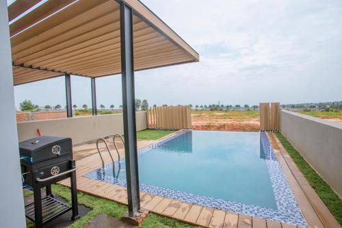 a swimming pool with a pergola and a grill at Villa Golf Novaworld in Bình Sum