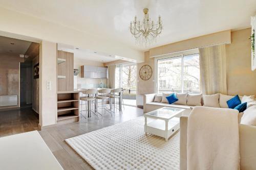 un salon et une cuisine avec un canapé et une table dans l'établissement Le Clos - 4 pers - Balcony - Wifi - Stade de France, à Aubervilliers