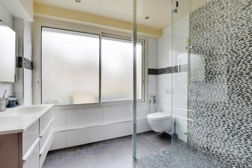 une salle de bain avec toilettes et douche en verre dans l'établissement Le Clos - 4 pers - Balcony - Wifi - Stade de France, à Aubervilliers