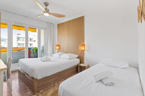 deux lits dans une chambre d'hôtel avec une fenêtre dans l'établissement Le Chambord - Hypercentre - Spacious - Terrace, au Cannet