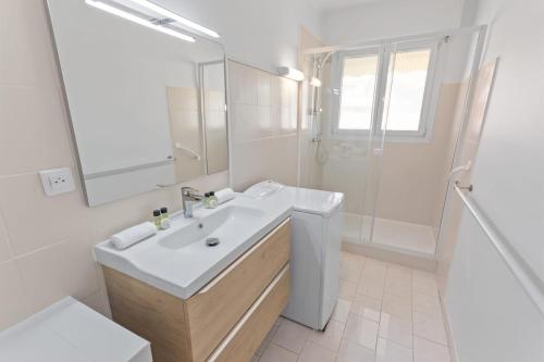 une salle de bain blanche avec un lavabo et une douche dans l'établissement Le Chambord - Hypercentre - Spacious - Terrace, au Cannet