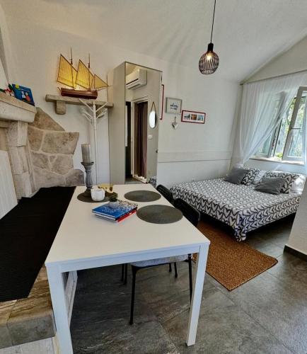 a living room with a white table and a couch at Studio apartment Matoni in Postira