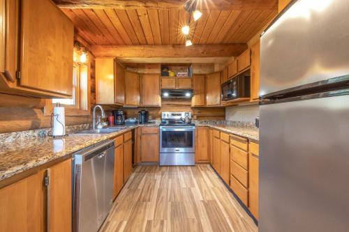 a kitchen with wooden cabinets and stainless steel appliances at Rowland Log Cabin in Lyle