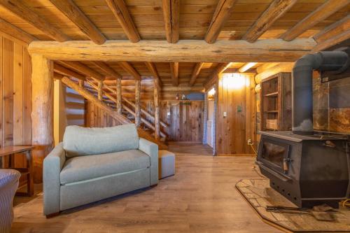 a living room with a couch and a stove at Rowland Log Cabin in Lyle