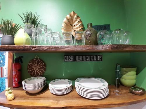 a wooden shelf with plates and glasses on it at Bella Vita Casitas - Bella Verde in Placencia Village