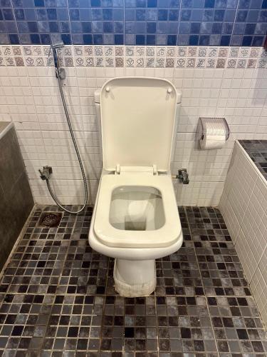 a bathroom with a white toilet in a stall at Costa Verde Luxury Seafront Villa in Chennai