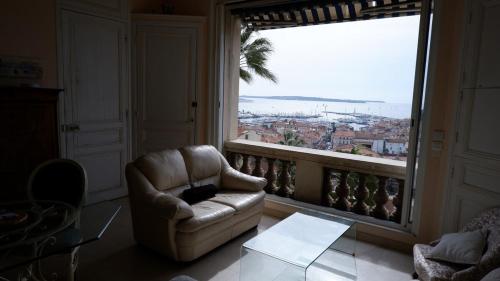 un salon avec un canapé et une grande fenêtre dans l'établissement CANNES STUDIO Vue Mer, à Cannes