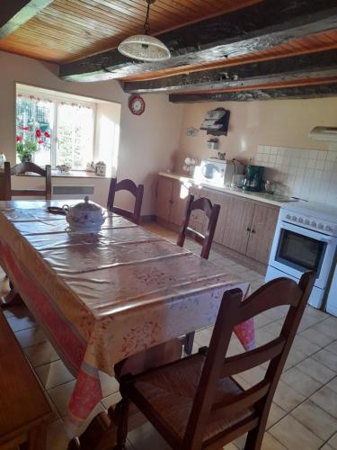 une cuisine avec une grande table en bois et des chaises dans l'établissement Une maison rien que pour vous, à Cléguérec