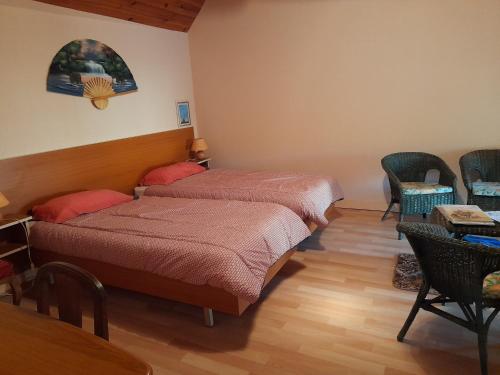 une chambre avec deux lits, une table et des chaises dans l'établissement Une maison rien que pour vous, à Cléguérec