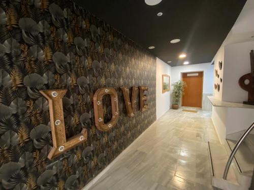 a wall with a love sign in a hallway at Apartamentos el Sótano in Badajoz