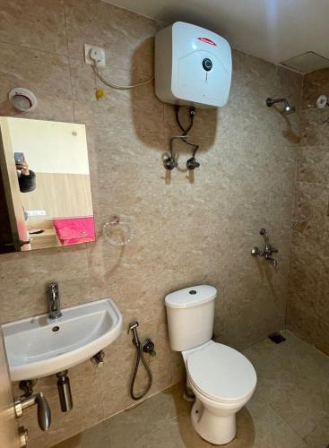 a bathroom with a toilet and a sink at Krishna's Braj in Chhatikara