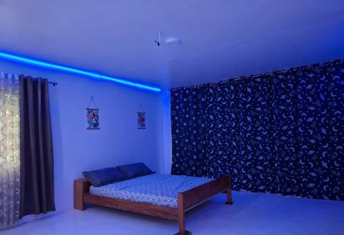 a room with a bed and a blue light at Remy's Eco house in Hernani