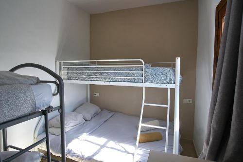 a small room with a bunk bed and a ladder at Olive Branch El Chorro in El Chorro