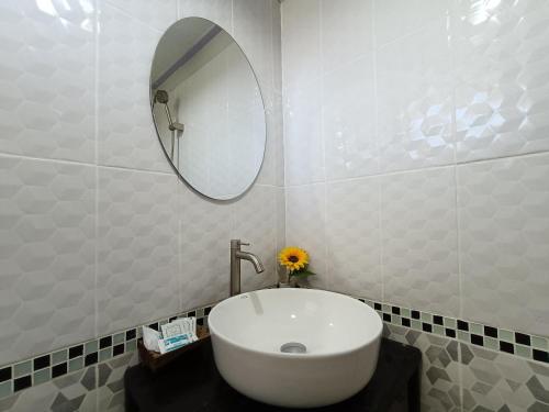 a bathroom with a white sink and a mirror at Cherlyn Homestay เฌอลินน์โฮมสเตย์ เกาะลิบง in Ban Batubute