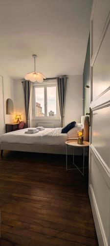 une chambre avec un grand lit et une fenêtre dans l'établissement Appartement T3 centre ville Parking, à Dinan