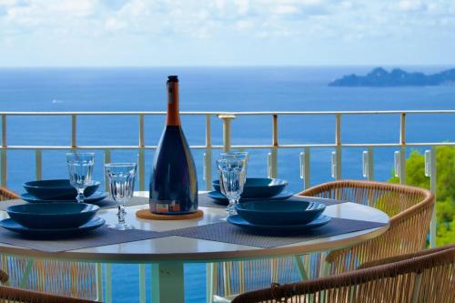 a table with a bottle of wine and glasses on a balcony at Tigullio Blue Experience - Portofino Luxury View in Villa Solari