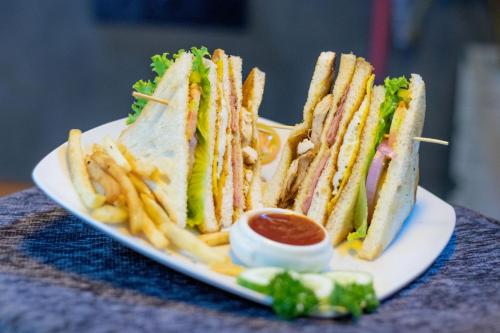 a white plate with a sandwich and french fries at A2 HavenX in Hikkaduwa
