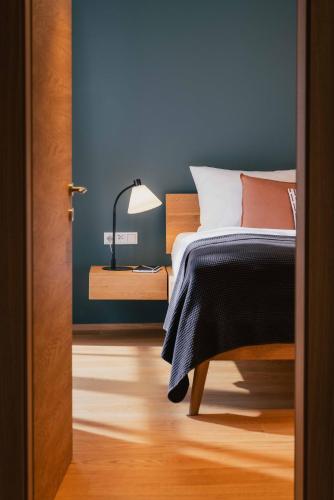 a bedroom with a bed and a blue wall at Hallstatt-Haus Elfriede in Hallstatt