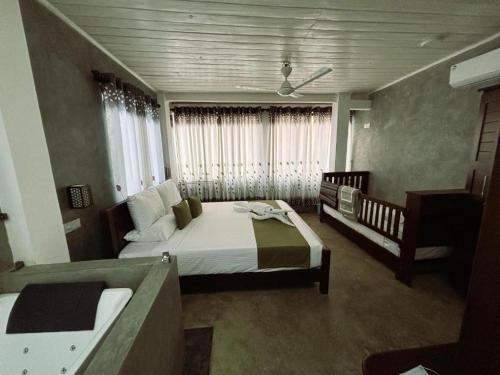 a bedroom with two beds and a crib at A2 HavenX in Hikkaduwa
