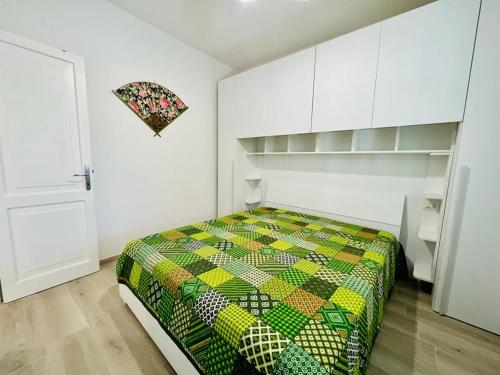 a bedroom with a bed with a colorful quilt at Residence Oasi La Cinta Centro in San Teodoro