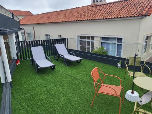 a yard with chairs and tables and a fence at Casa Pereira 1 in Ponta do Pargo