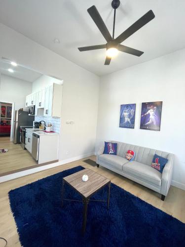 a living room with a couch and a ceiling fan at Retro Baseball Downtown Apartment in Saint Louis