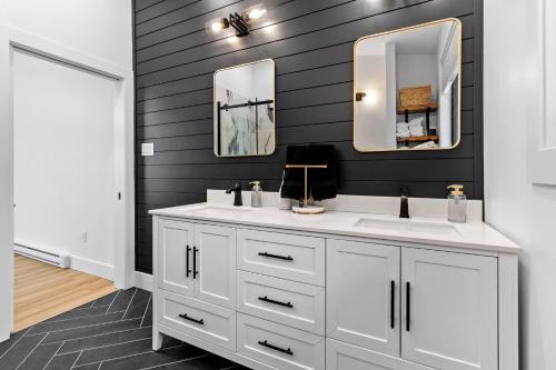 a bathroom with a white sink and two mirrors at Flatrock Ocean View Sauna 3B 35BA in Flat Rock