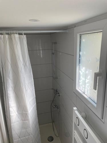une salle de bain avec une douche avec un rideau de douche dans l'établissement Maison avec vue mer à Omaha Beach - idéal familles, à Saint-Laurent-sur-Mer
