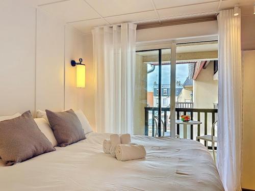 un lit blanc avec un animal rembourré au dessus dans l'établissement Urban Elite YourHostHelper, à Deauville