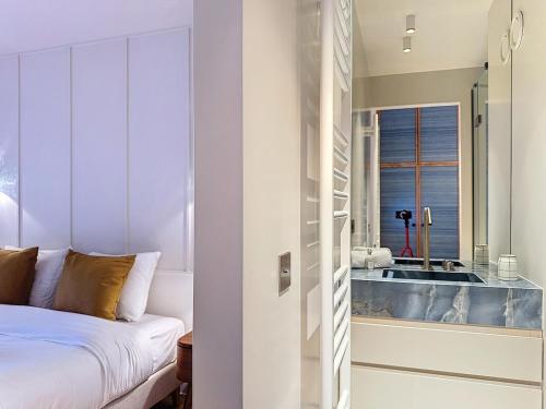 - une chambre avec un lit et une baignoire à côté d'une fenêtre dans l'établissement Urban Elite YourHostHelper, à Deauville